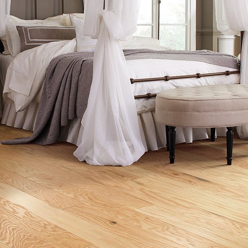 White and brown bed on hardwood floor from Prestige Flooring Center in Cathedral City, CA